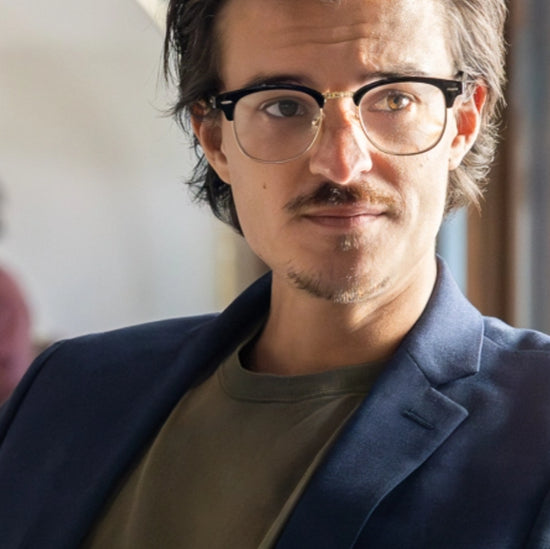 close up of a male in a suite wearing glasses