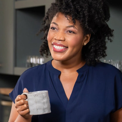 headshot of a woman with a coffee mug in her hand
