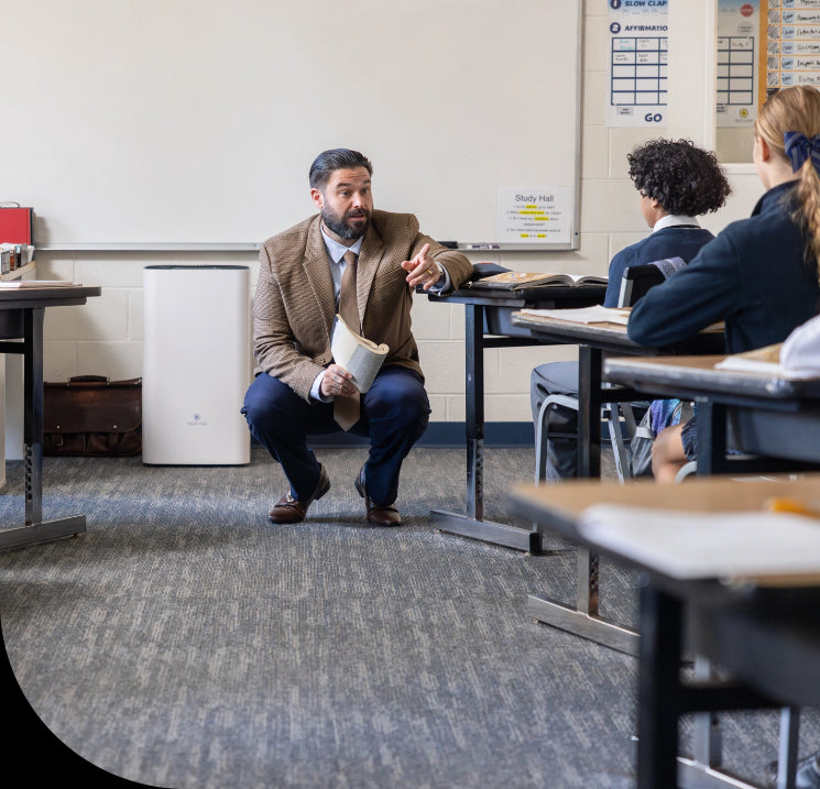 a teacher in a classroom with an air purifier