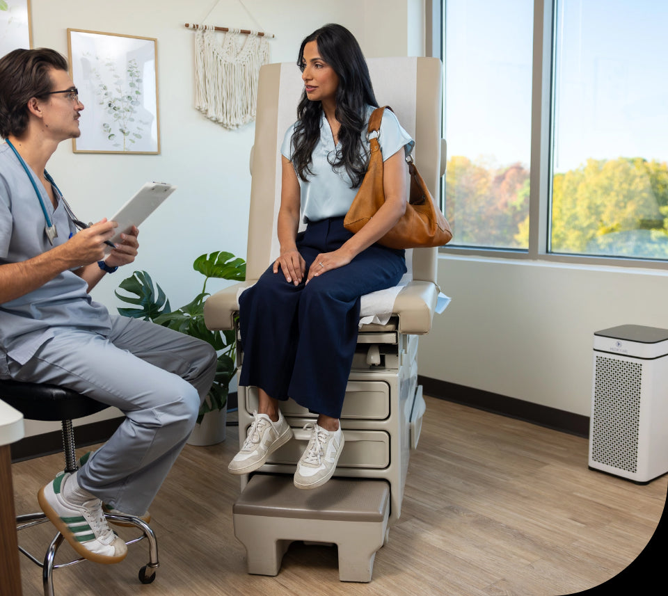 female sitting on a doctors table chating with a doctor