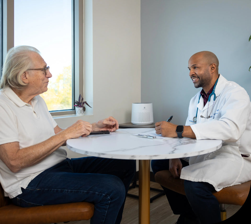 a doctor talking to a long term care resident with an air purifier in the background