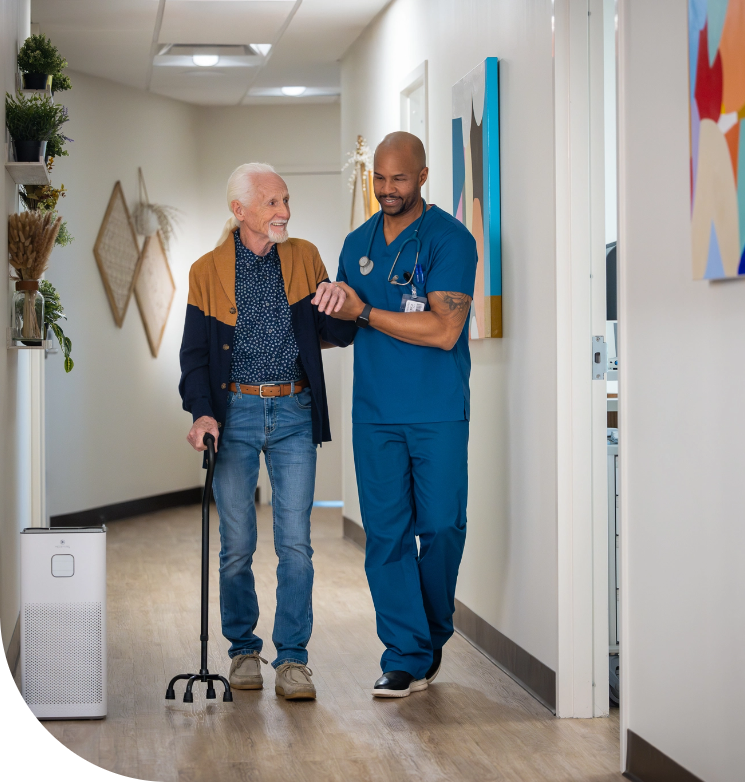 a doctor walking a patient in hospital hallway with an air purifier in the background