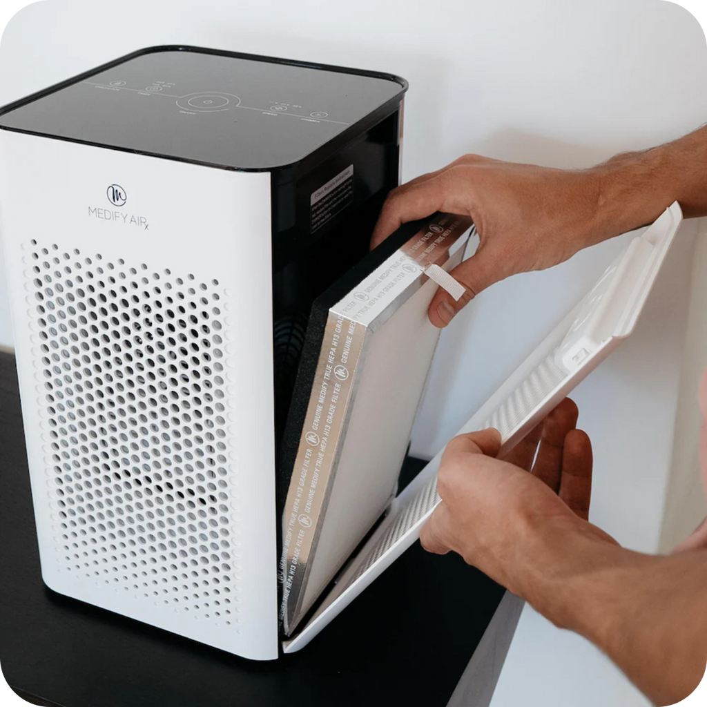 a person changing out their air filter on an air purifier